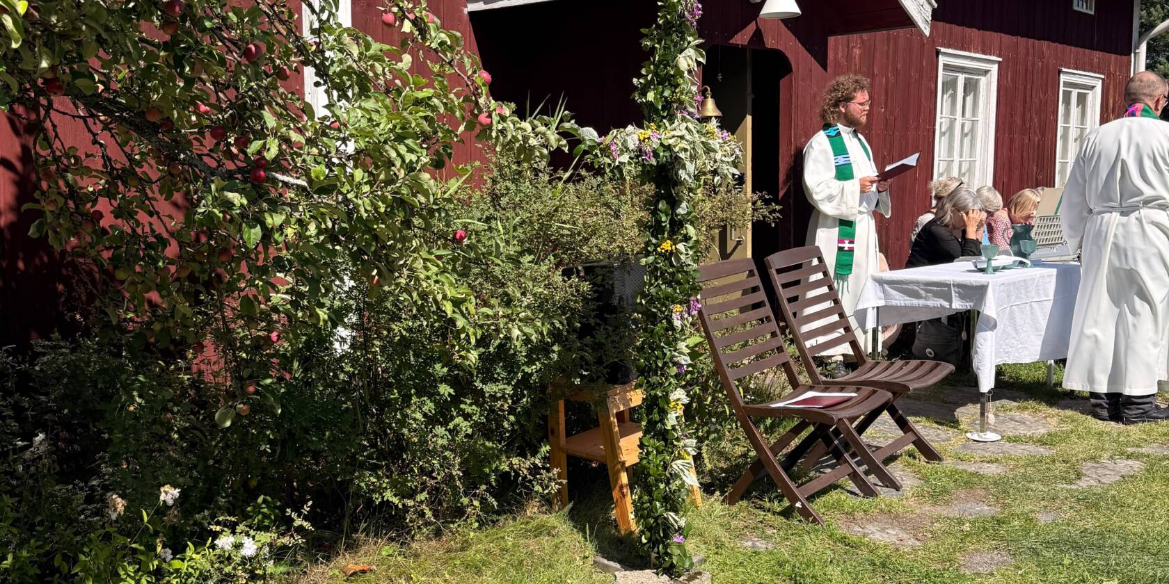 punainen torppa ja kaksi pappia