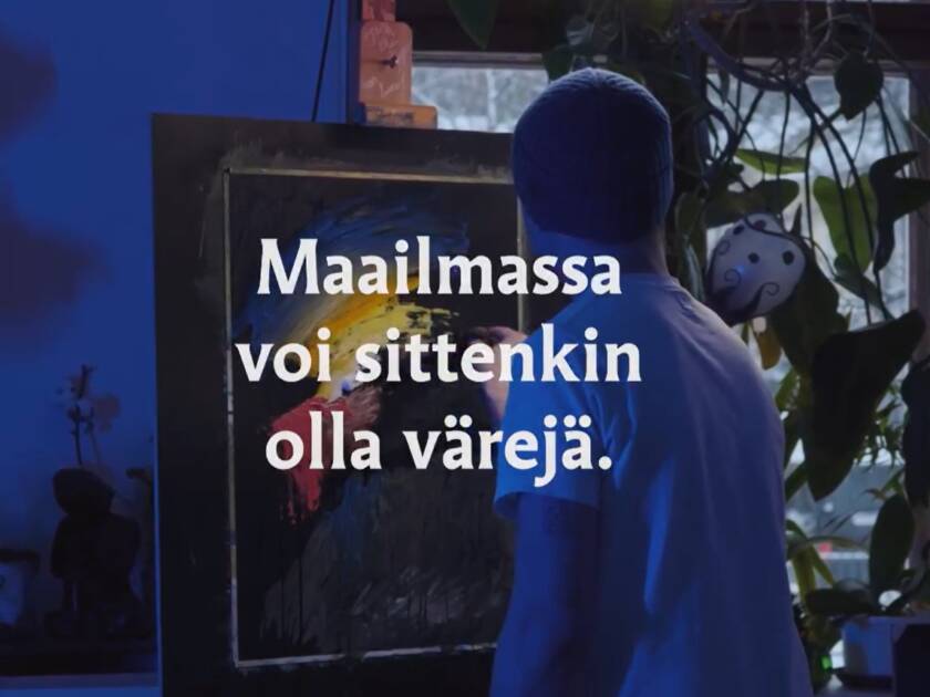Maailmassa voi sittenkin olla värejä. Nuori maalaamassa taulua.