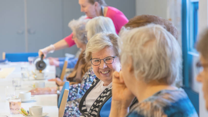 Eläkeläiset juttelevat kahvin äärellä.