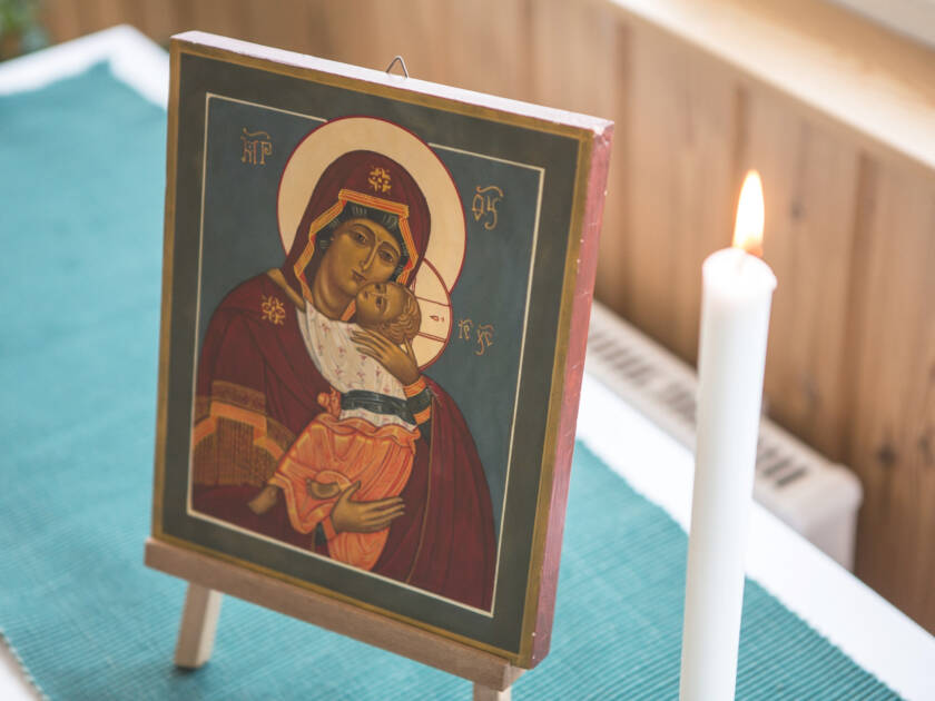 Ikoni, jossa on neitsyt maria ja Jeesus-lapsi, ja kynttilä ikonin vieressä.