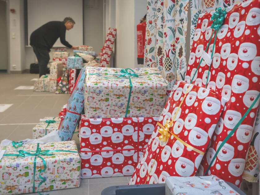 Ett stort antal inslagna julklappar i högar på golvet.