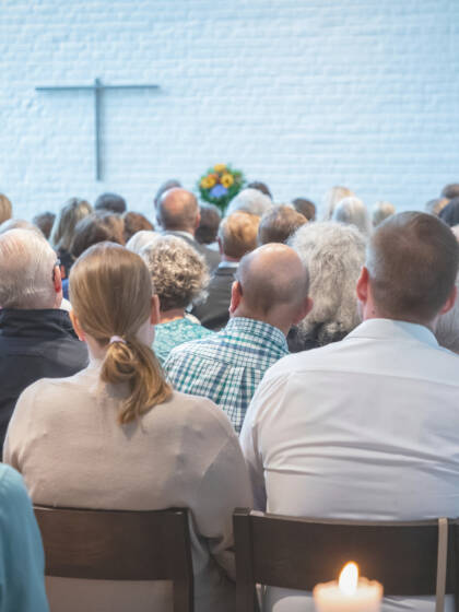 Ihmisiä kirkkosalissa jumalanpalveluksessa.