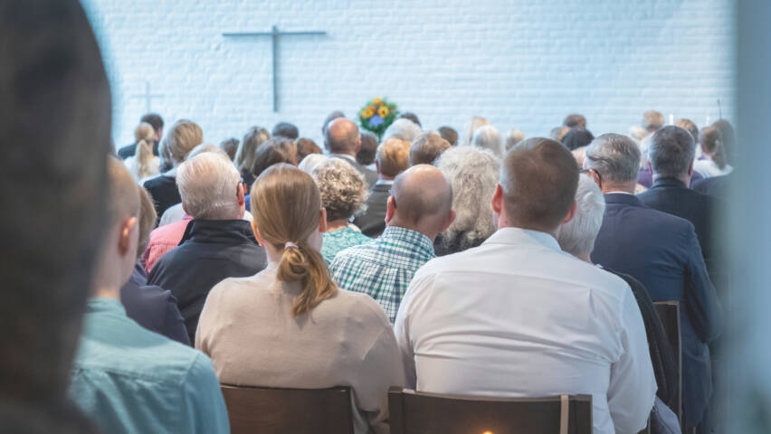 Ihmisiä kirkkosalissa jumalanpalveluksessa.