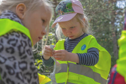 Pikkutyttö leikkii muovailuvahalla pihalla.