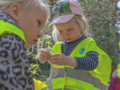 Pikkutyttö leikkii muovailuvahalla pihalla.