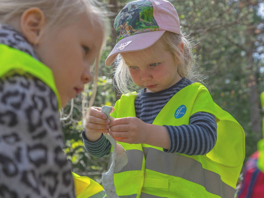 Pikkutyttö leikkii muovailuvahalla pihalla.