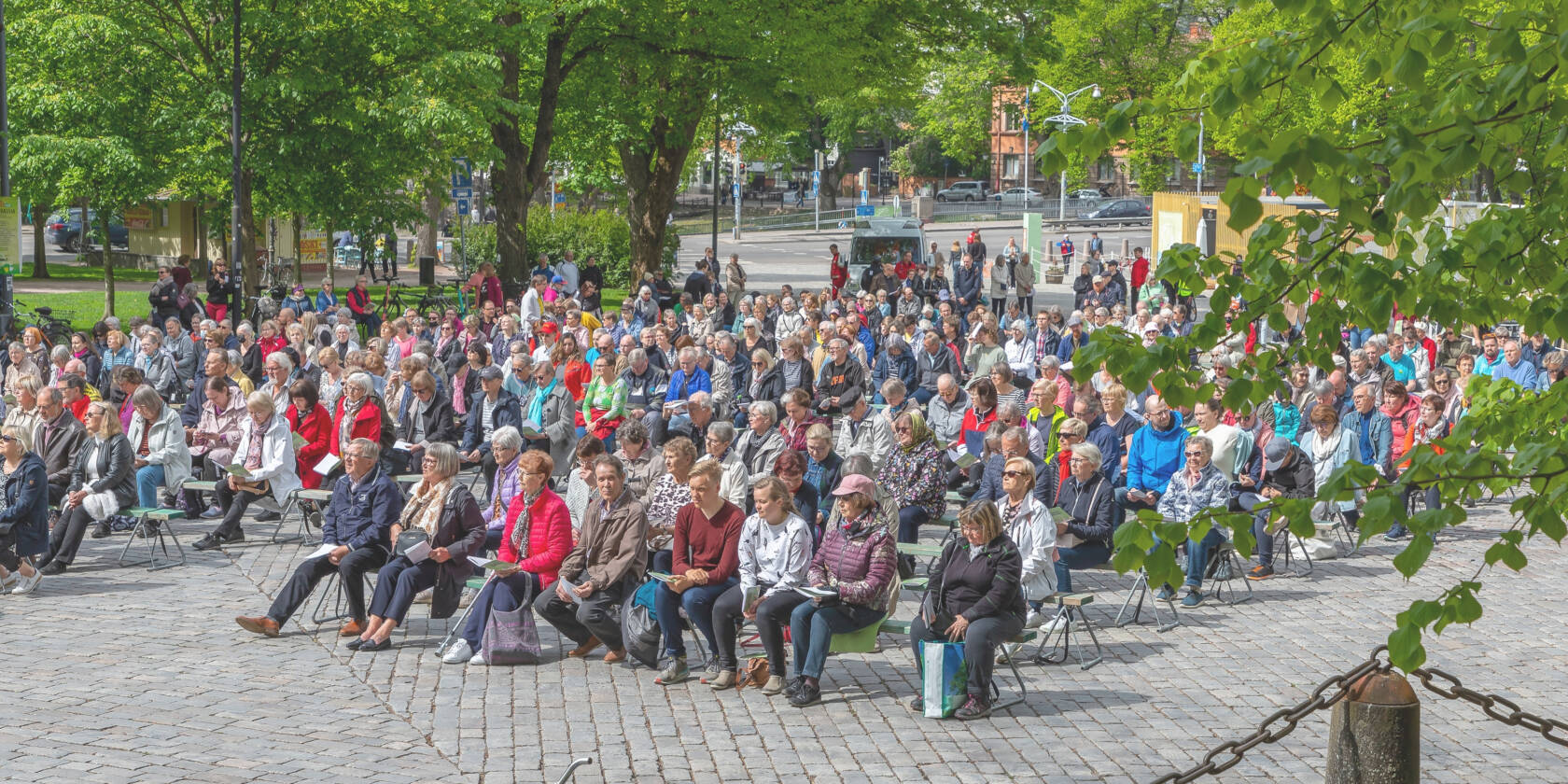 People sitting on benches in front of Turku Cathedral.