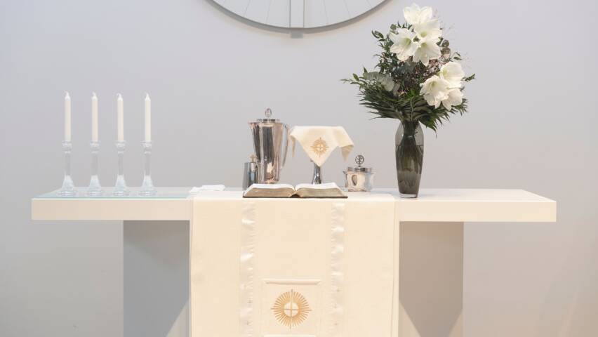 Alttarikuva, kukat ja ehtoollisvälineet.