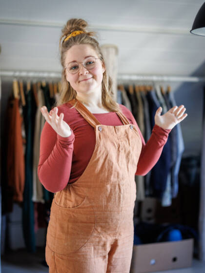 Eveliina Meriö vaatehuoneen rekin edessä.