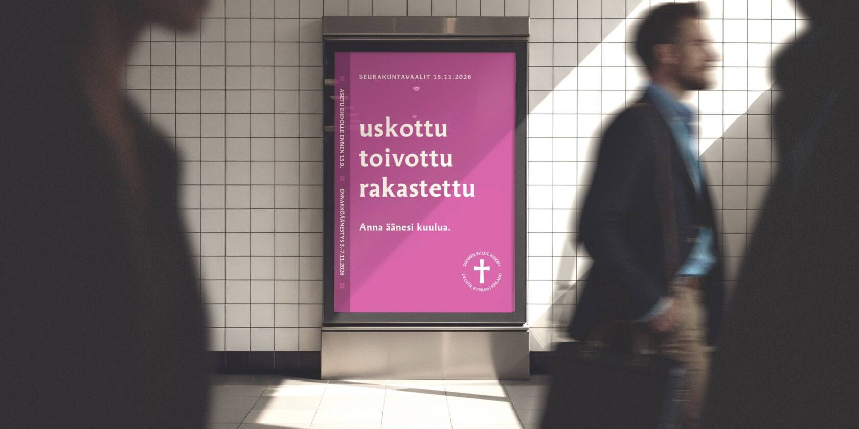 Juliste, jossa on violetti tausta ja teksti "uskottu toivottu rakastettu". Taustalla kulkee ihmisiä, jotka ovat liikkeessä.