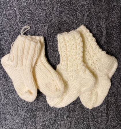 Vita yllesockor mot en grå bakgrund.