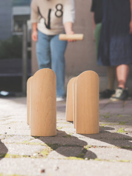 Ihmisiä pelaamassa mölkkyä.
