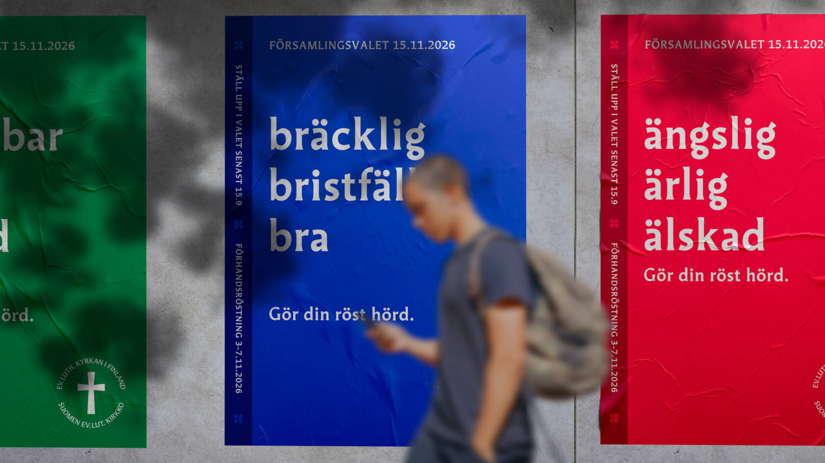 Tre affischer på en vägg med olika färger och texter. En person går förbi, i bakgrunden syns en röd, blå och grön affisch.
