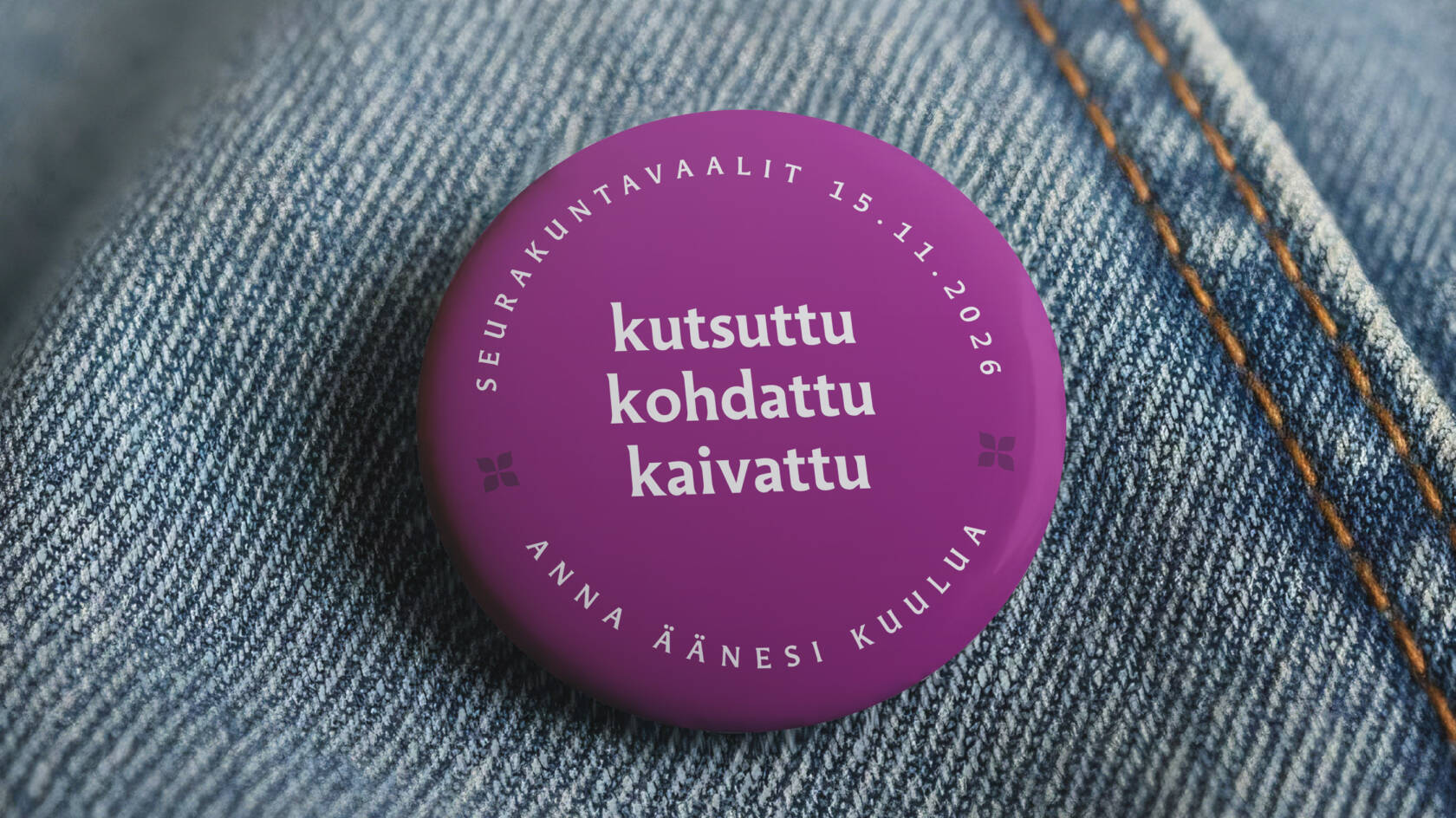 Violetti rintamerkki farkkukankaalla, teksti "kutsuttu, kohdattu, kaivattu" ja päivämäärä "15.11.2026".