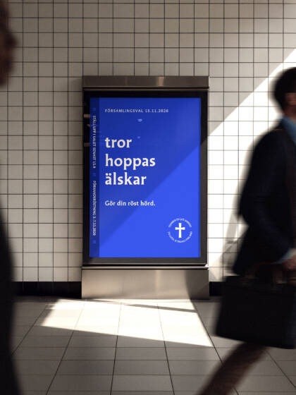 En affisch med texten "tros hoppas älskar" och "Gör din röst hörd", med rörliga människor i bakgrunden på en tunnelbanestation.