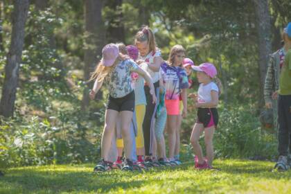 Kouluikäiset tytöt ovat jonossa, jalat pitkissä monen henkilön suksissa.
