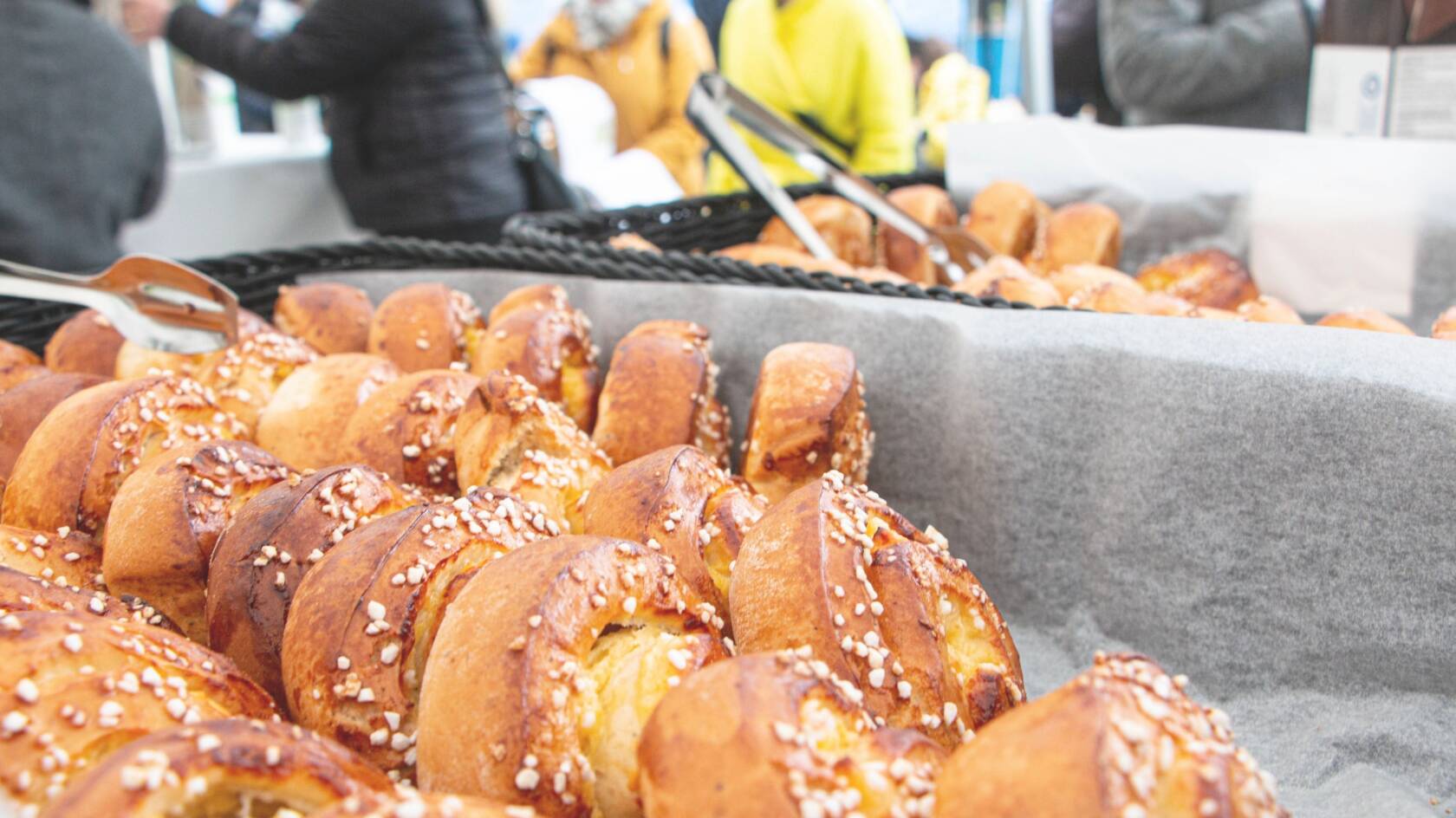 Etualalla paljon pullia ja taustalla ihmisiä keskustelemassa.