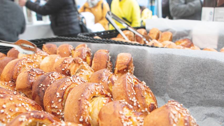 Etualalla paljon pullia ja taustalla ihmisiä keskustelemassa.