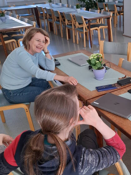 Nainen nauraa hersyvästi, etualalla toinen