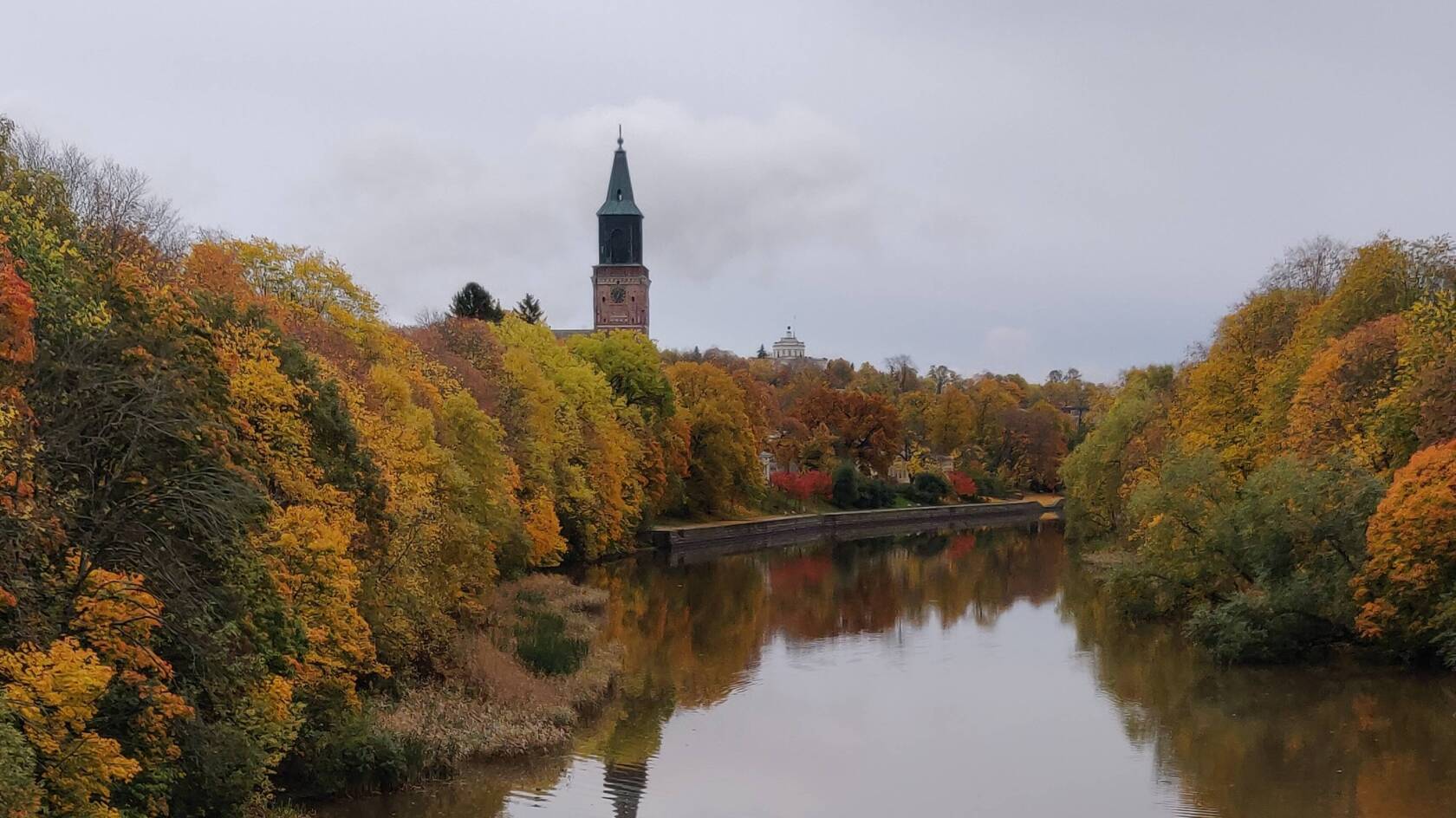 Aura å i höstskrud med Åbo domkyrka i bakgrunden.