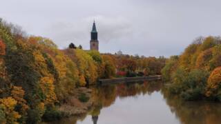 Aura å i höstskrud med Åbo domkyrka i bakgrunden.