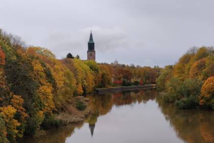 Aura å i höstskrud med Åbo domkyrka i bakgrunden.
