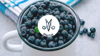 valkoinen emalimuki mustikoita täynnä, marttojen logo.