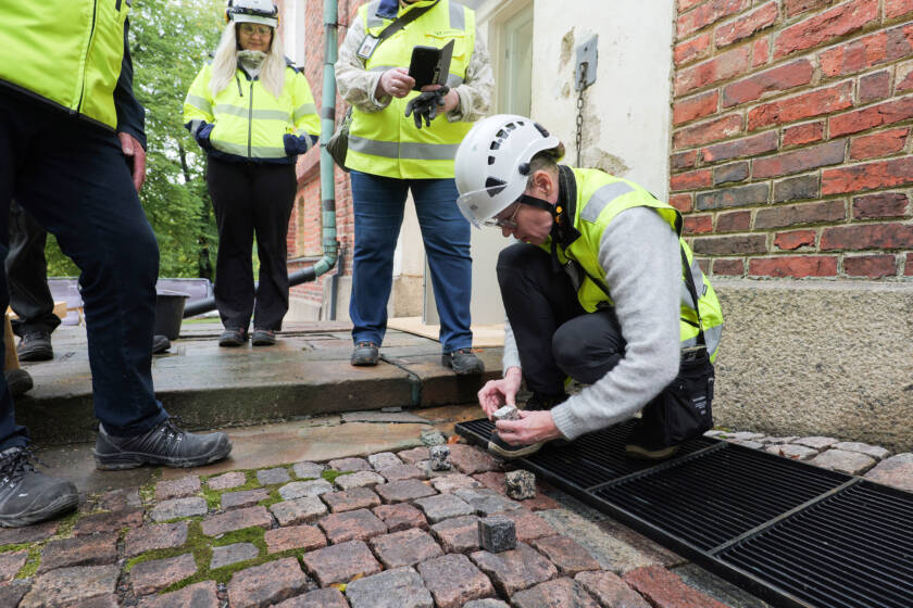 A designer kneeling beside the cathedral to inspect the paving stones
