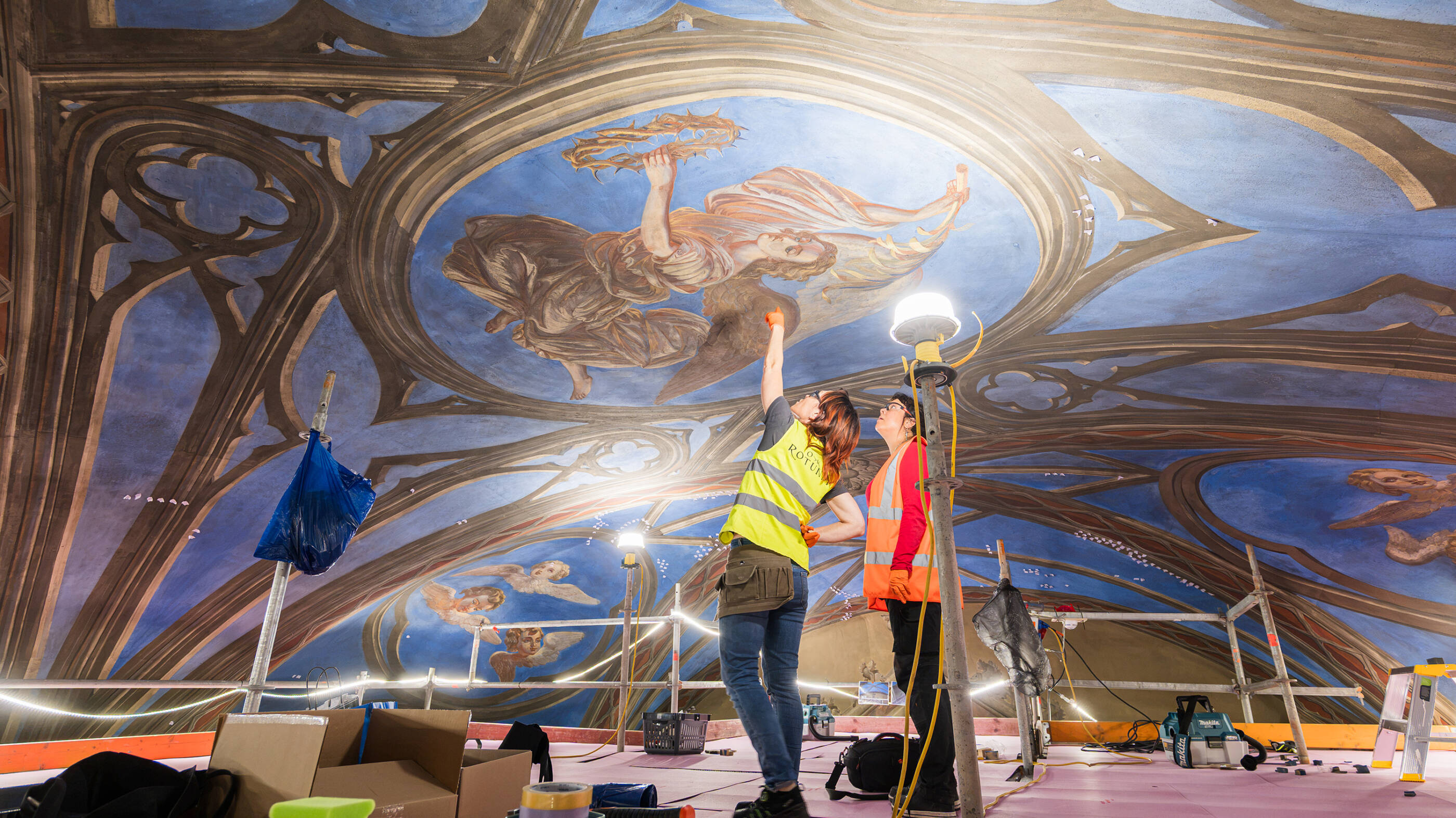 Two people beneath an angel fresco.