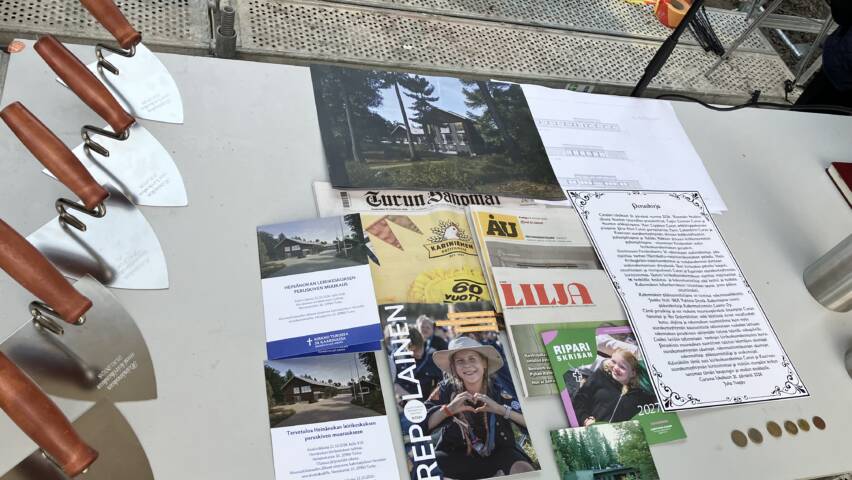 Muurauslastoja ja aikakapselin aineisto pöydällä.